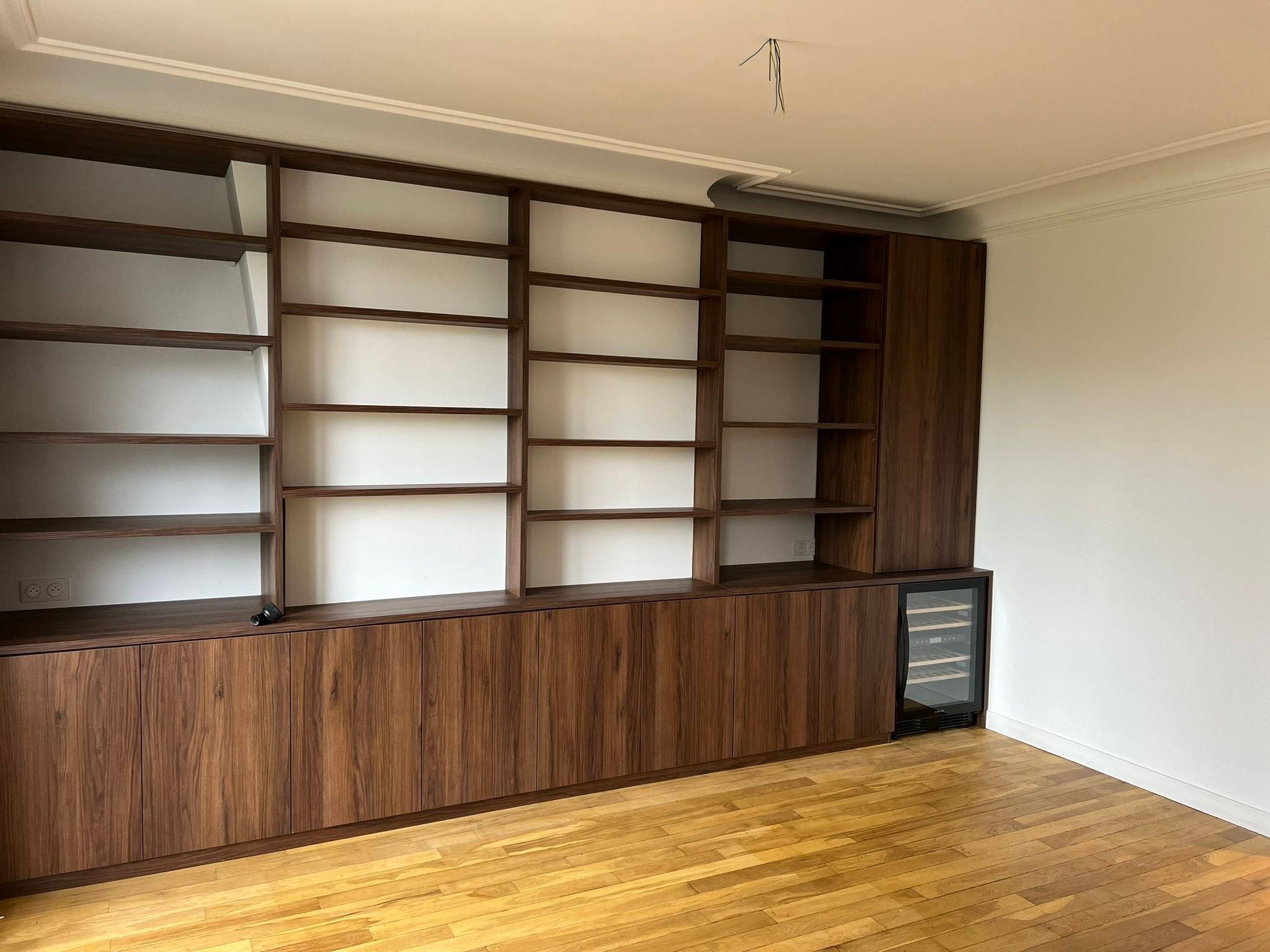 Bibliothèque murale en noyer avec rangements bas et cave à vin intégrée, à Paris 10e
