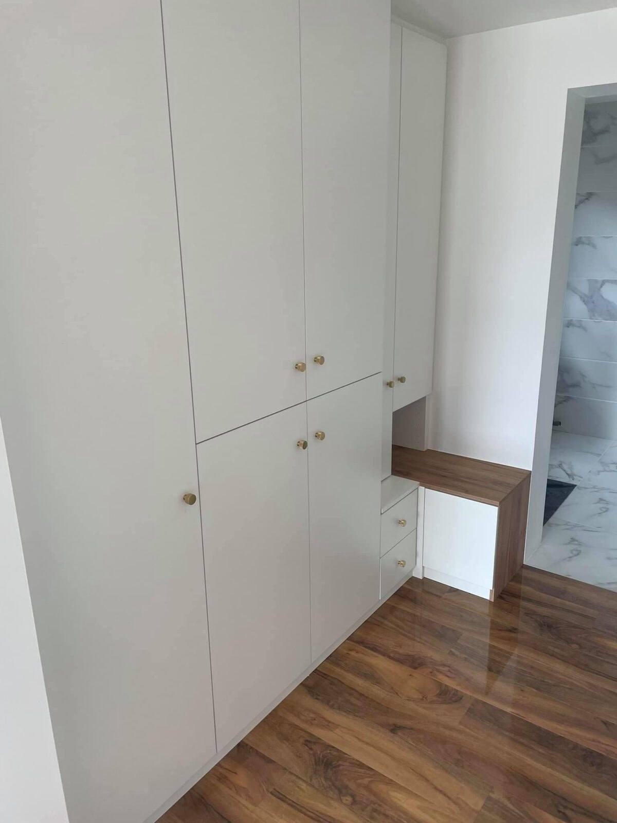 Placard blanc sur mesure avec banc bois, dans un couloir
