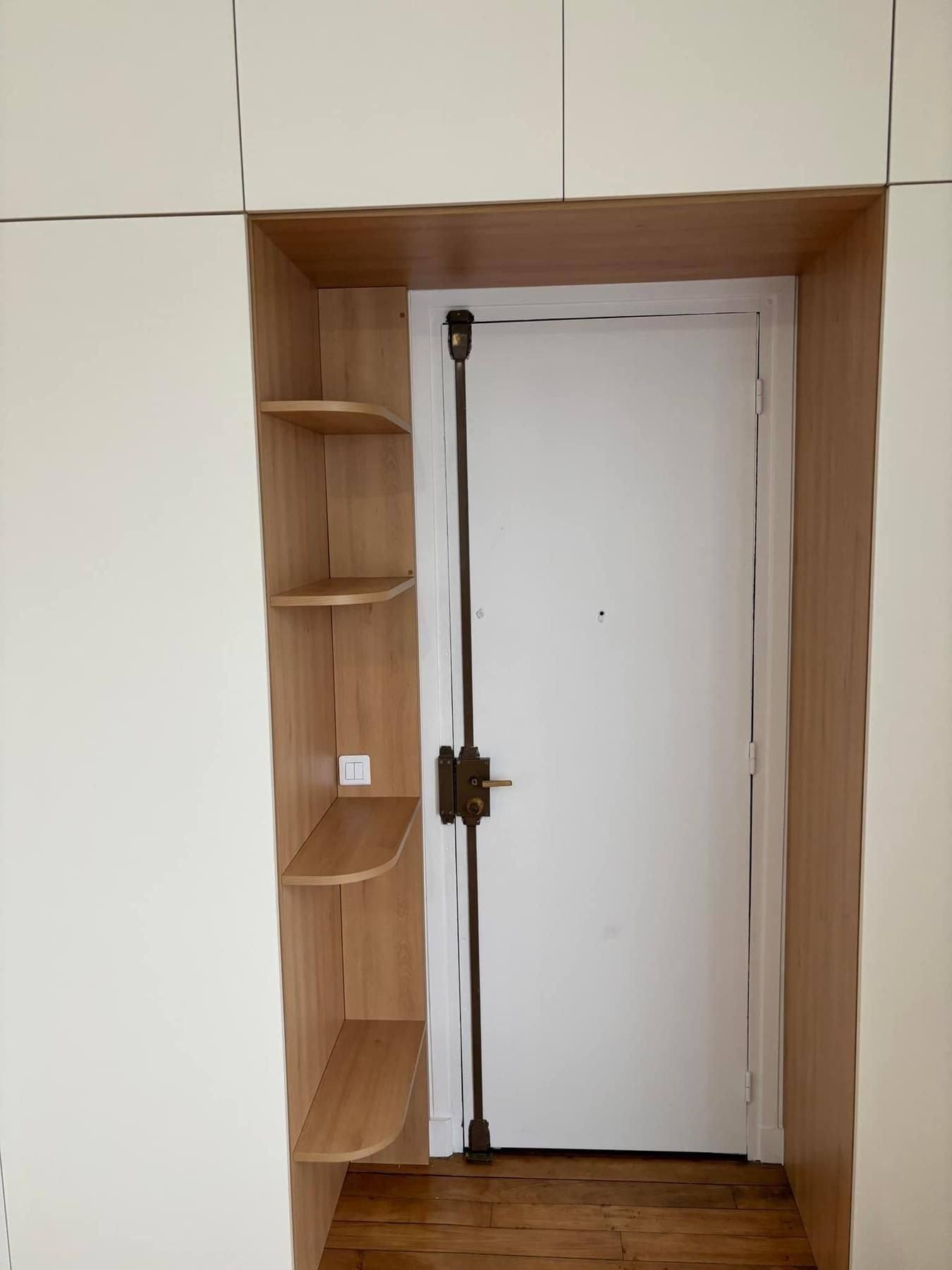 Placard d'entrée sur mesure encadrant la porte, avec étagères d'angle en bois, à Paris 10e
