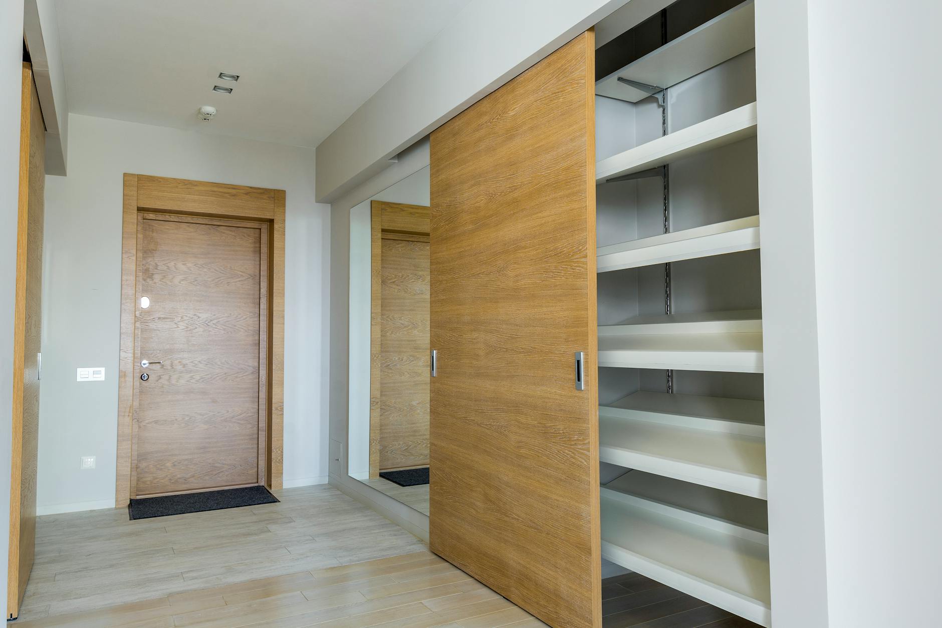 Portes coulissantes en bois clair pour un placard sur mesure dans un salon lumineux